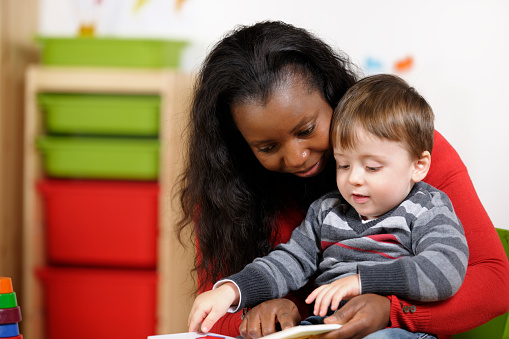 Toddler Enjoying Storytime With His Carer